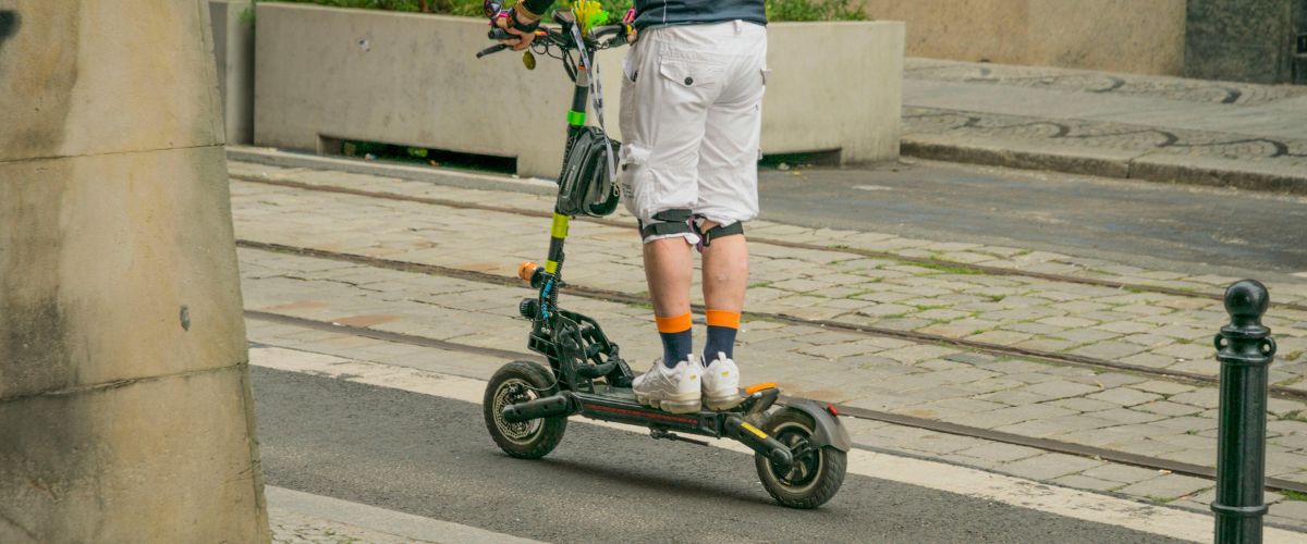 Homme sur une trottinette électrique à grande vitesse équipé de protections