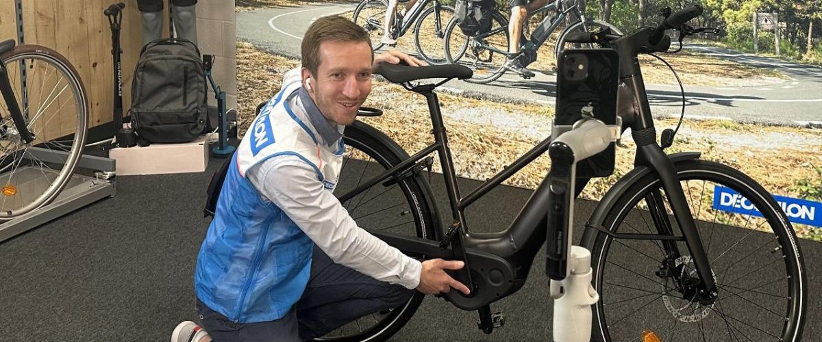 Vendeur Decathlon devant un vélo électrique