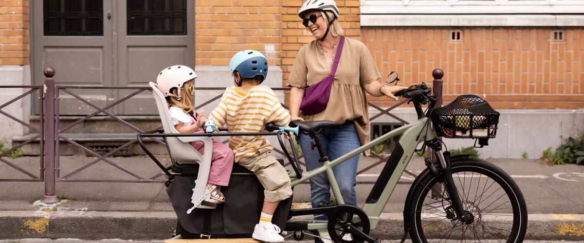 Une maman avec ses deux enfants sur un vélo électrique Decathlon