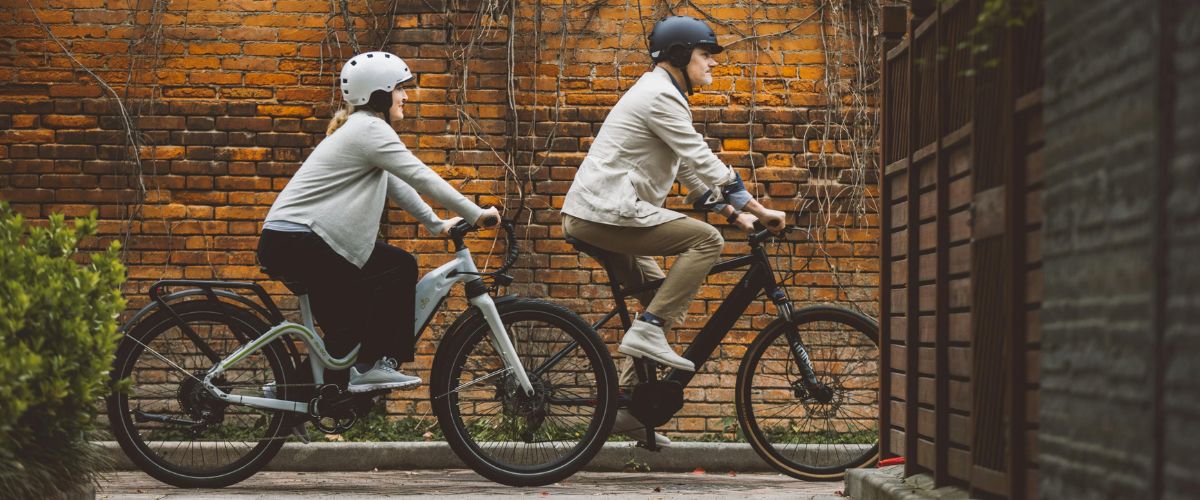 Deux personnes sur un vélo électrique en ville