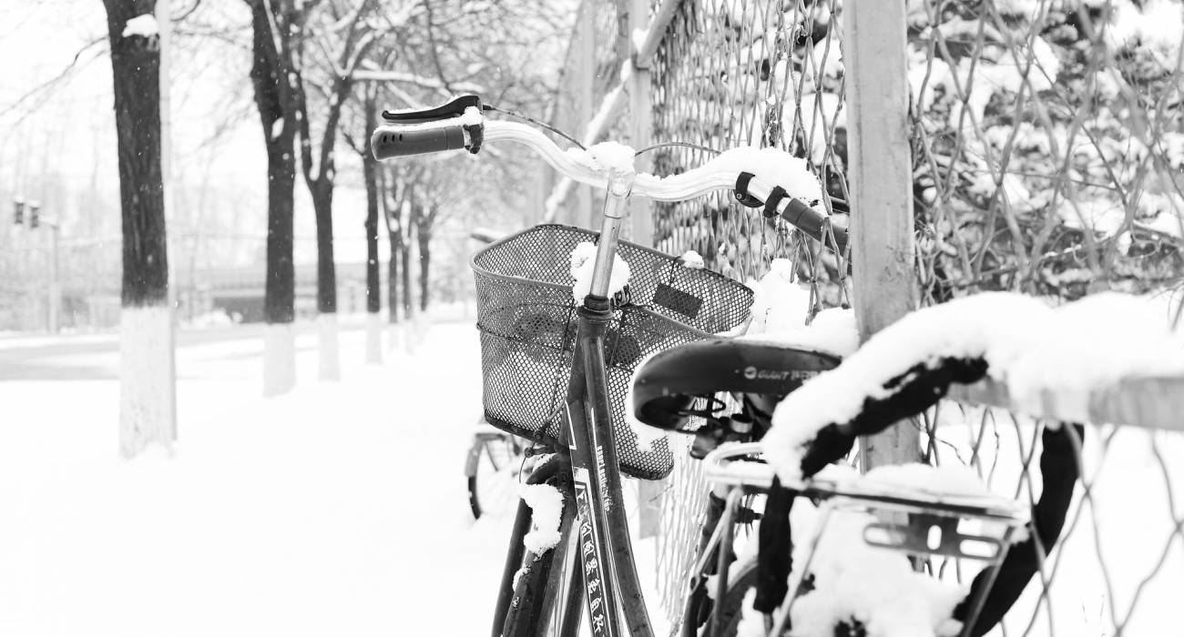 Vélo contre un grillage sous la neige