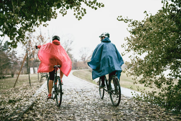 Deux personnes à vélo sous la pluie avec kway
