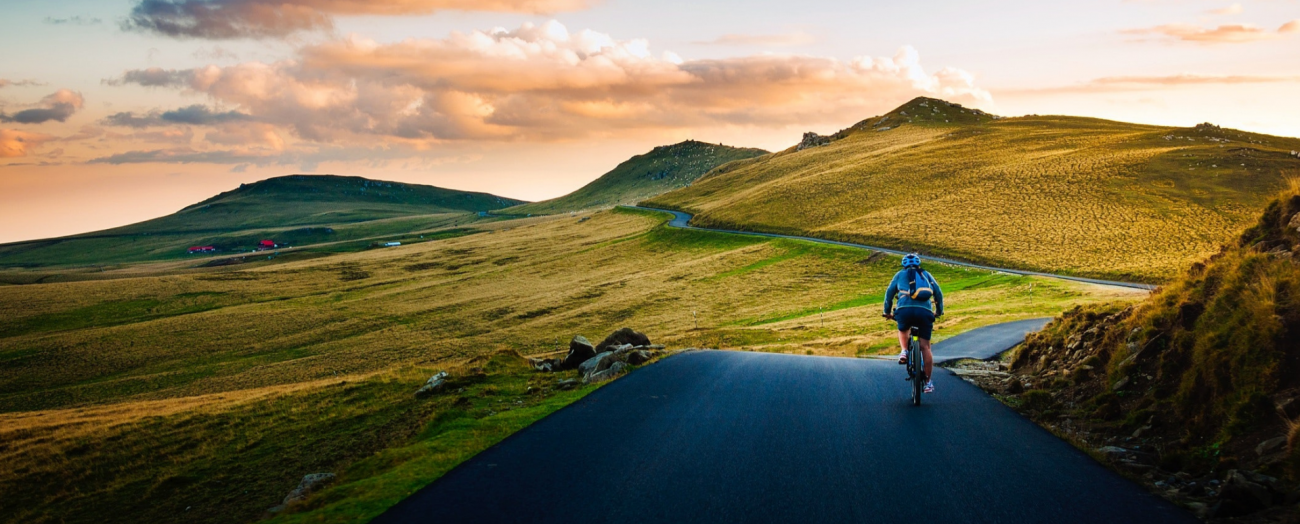 Homme en vélo avec coucher de soleil